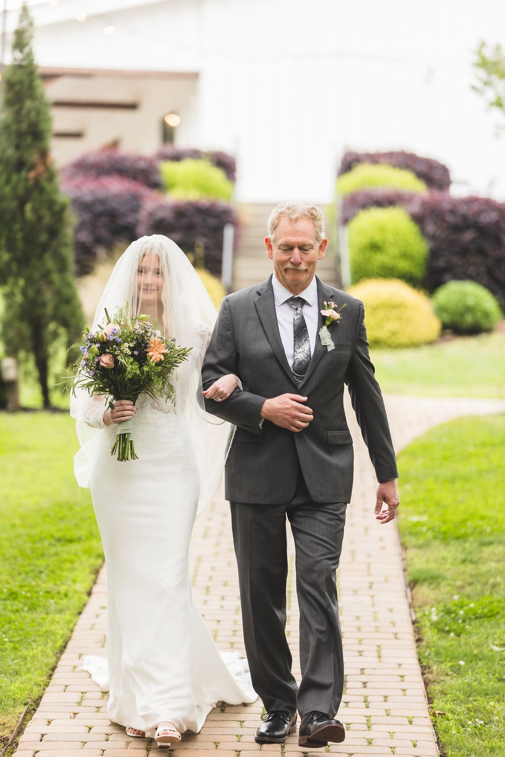 Brautvater führt seine Tochter im Brautkleid zum Altar