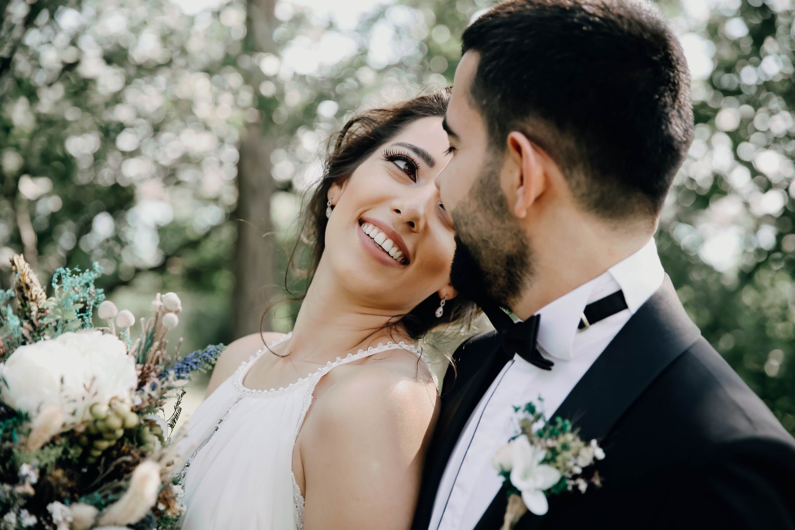 Glückliches Brautpaar lächelt sich am Hochzeitstag an
